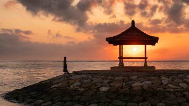 Woman with sunshine in pavilion on jetty at coastl