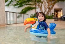 Portrait of little boy in swimming pool on funny i