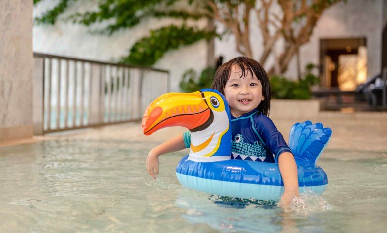 Portrait of little boy in swimming pool on funny i