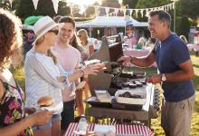 Man serving on barbeque stall at summer garden fet