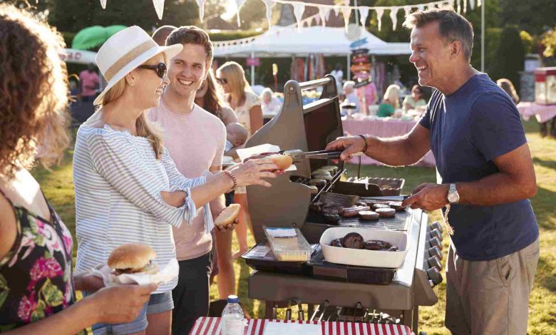 Man serving on barbeque stall at summer garden fet