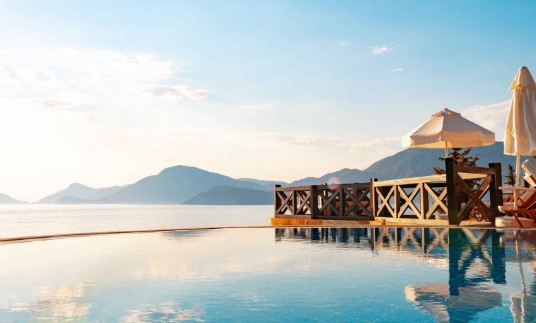 Infinity swimming pool with sea view against blue