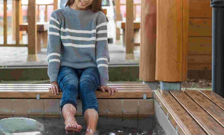 Woman soaking feet in foot bath outdoors