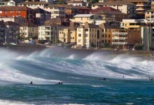 Surfers enjoying large waves near coastal city
