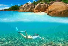 Woman with mask snorkeling in clear water at seych