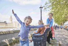 Mother and sons on bench by river thames