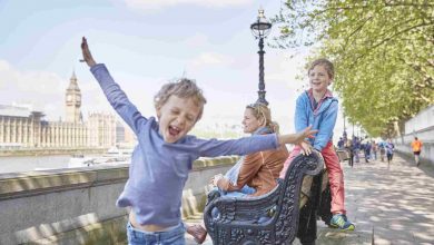 Mother and sons on bench by river thames