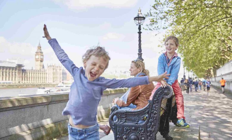 Mother and sons on bench by river thames