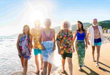 Happy group of senior friends bonding at the beach