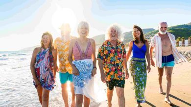 Happy group of senior friends bonding at the beach