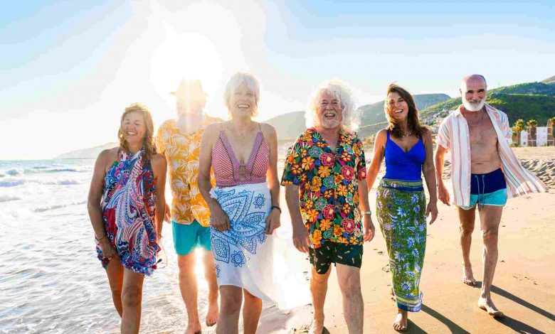 Happy group of senior friends bonding at the beach