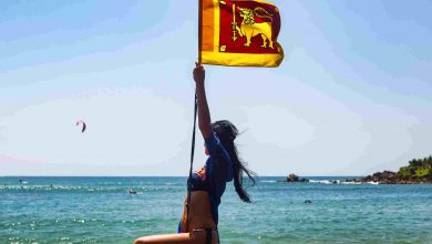 Carefree woman swinging on beach with flag