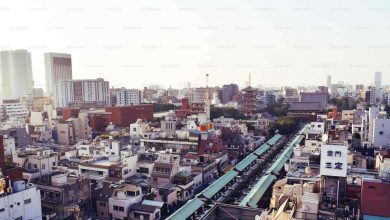 A train traveling through a city next to tall buil