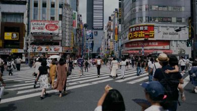 A group of people walking across a street