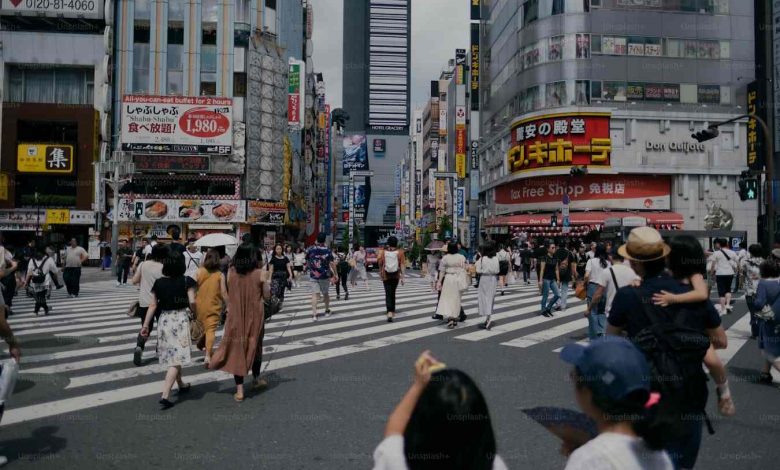 A group of people walking across a street
