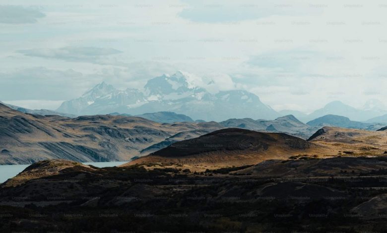 A view of a mountain range with a lake in the fore