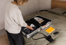 Someone is packing a suitcase on a bed