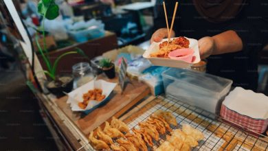 A person holding a tray of food on a table