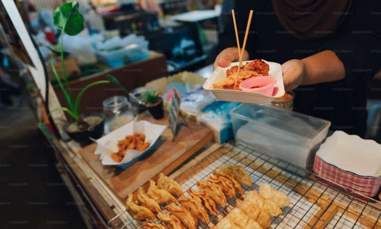 A person holding a tray of food on a table