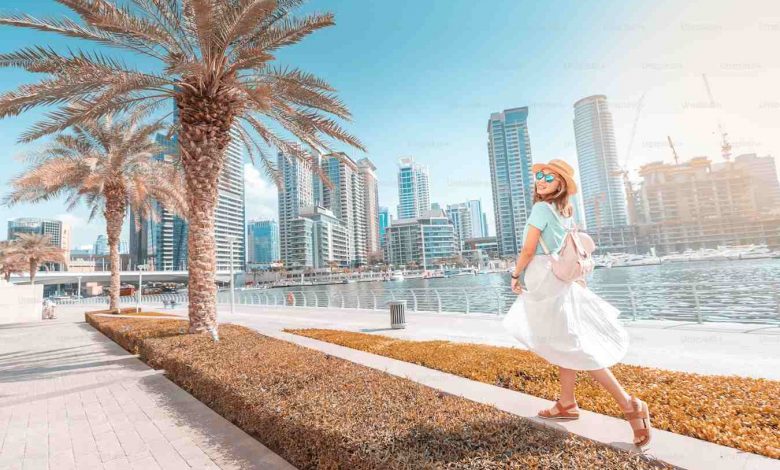 Happy asian girl walking on a promenade in dubai m