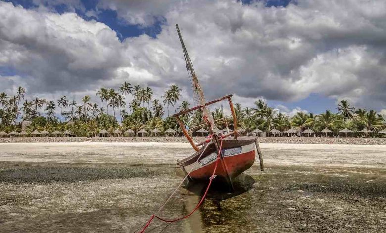 A boat sitting on top of a sandy beach